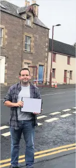  ??  ?? Campaign Craig Finlay pictured previously at the junction with a petition signed by more than 200 people calling for increased safety measures