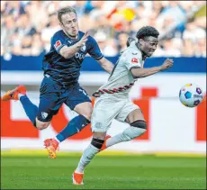  ?? David Inderlied The Associated Press ?? Bayer Leverkusen midfielder Nathan Tella races past Bochum defender Felix Passlack in Leverkusen’s 5-0 victory Sunday. It hasn’t lost since May 27 of last year.