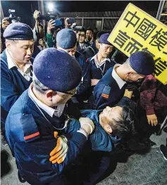  ??  ?? A man is removed by members of security as he takes part in a NewYear’s Day pro-democracy rally in Hong Kong at the recently reopened Civic Square. — AFP photo