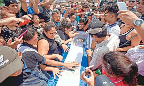  ??  ?? Tragedia. Yadia Córdoba, madre de Orlando, se despide emotivamen­te de su hijo antes de depositar el féretro en el cementerio Milagro de Dios, de Managua. El joven, de 15 años, fue atacado a balazos por miembros de las fuerzas de seguridad de Nicaragua....