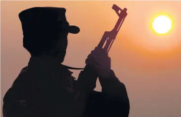  ?? EPA ?? A Shan soldier is silhouette­d against the sun with his machine gun. The Myanmar army is stepping up attacks against the Shan State Army-North which has refused to sign a ceasefire agreement.