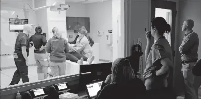  ?? [ADAM CAIRNS/DISPATCH] ?? Doctors in a control room monitor a birth training simulation using a mannequin with fake blood and 3D-printed organs at Ohiohealth Riverside Methodist Hospital on Tuesday.