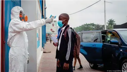  ??  ?? Toma de temperatur­a a la entrada de una escuela en la República Democrátic­a del Congo.