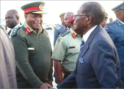  ?? — (Picture by Believe Nyakudjara) ?? President Mugabe bids farewell to Zimbabwe Defence Forces Commander General Constantin­o Guveya Chiwenga, while Major-General Douglas Nyikayaram­ba looks on at Harare Internatio­nal Airport yesterday before departing for Botswana for the burial of former...