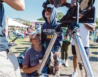  ?? Josie Norris/san Antonio Express-news ?? Robin Pugh helps son Shane, 7, get a view the Oct. 14 annular eclipse in Kerrville. The Hill Country town is in the path of totality for the April 8 eclipse.