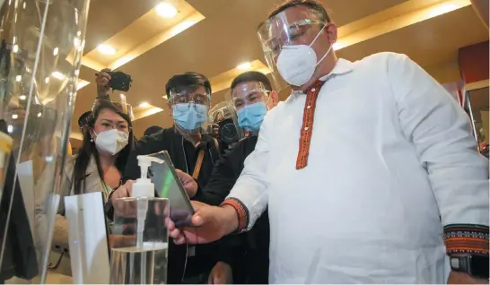  ?? Photo by Jean Nicole Cortes ?? CASHLESS. Presidenti­al Spokespers­on Harry Roque use cashless payments while purchasing goods at a local shop along Session Road, Friday morning as Baguio City is set to reopen its doors for local tourists.