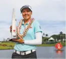  ?? Jamm Aquino / Star-Advertiser ?? Brooke Henderson holds the trophy after winning the LPGA Lotte Championsh­ip golf tournament in Kapolei, Hawaii, for her sixth LPGA Tour victory.