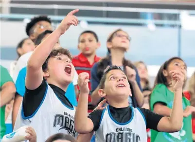  ?? JOE BURBANK/ORLANDO SENTINEL ?? Orange County Public Schools elementary students react to seeing themselves on camera during the Orlando Magic’s Pick, Read & Roll rally at Amway Center on Tuesday. The pep rally featured remarks from Magic players, a visit from a team mascot, games and music.