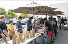  ??  ?? IN ADDITION to yoga instructio­n twice a week, Zefr provides employees with a catered lunch each day. Above, workers line up for burgers at the Venice start-up.