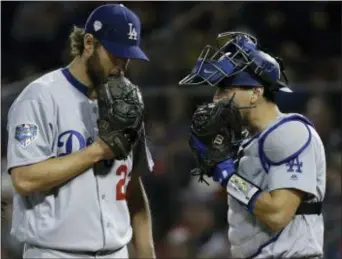  ?? MATT SLOCUM — THE ASSOCIATED PRESS ?? Los Angeles Dodgers’ Clayton Kershaw talks to Austin Barnes during the third inning of Game 1. Kershaw has been up and down in postseason starts.