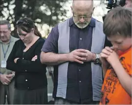  ?? Marcus Yam Los Angeles Times ?? PEOPLE pray after the 2015 shootings at Umpqua college in Roseburg, Ore.