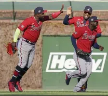  ?? GEtty iMaGES ?? THREE IS COMPANY: The Braves celebrate after beating the Cubs 5-2 at Wrigley Field yesterday.