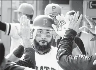  ?? KEITH SRAKOCIC / ASSOCIATED PRESS ?? Pirates first baseman Pedro Alvarez is greeted in the dugout after hitting a solo home run against the Cincinnati Reds in the fourth inning Sunday in Pittsburgh. The Pirates closed the regular season with a 4-0 victory.