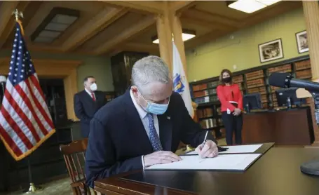  ?? NICOLAUS CZARNECKI / HERALD STAFF ?? GOING GREEN: Gov. Charlie Baker signs a new climate policy into law at the State House on Friday.