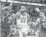  ?? Tony Dejak / Associated Press ?? The Cavaliers’ LeBron James, center, drives between the Jazz’s Ekpe Udoh, left, and Thabo Sefolosha in the second half Saturday.