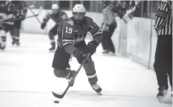  ?? [ALI WILSON / THE OBSERVER] ?? Tomas Azzano skates the puck over the blue line in Wellesley’s 1-0 loss to New Hamburg Saturday evening.