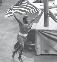  ?? ERICH SCHLEGEL, USA TODAY SPORTS ?? Boxer Claressa Shields carries a U. S. flag as she runs around the ring Sunday celebratin­g her gold medal victory.