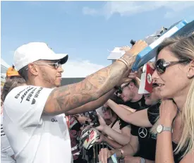  ??  ?? Mercedes driver Lewis Hamilton signs autographs ahead of the French GP.