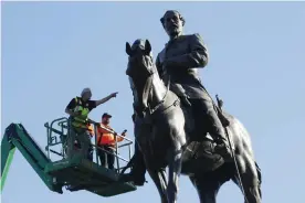  ?? Photograph: Steve Helber/AP ?? A crew from the Virginia department of general services inspect the statue of the Confederat­e general Robert E Lee on Monument Avenue in Richmond, Virginia, last year.