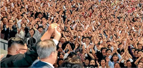  ?? AP ?? South Korean President Moon Jae-in, foreground right, and North Korean leader Kim Jong Un raise their hands after watching the mass games performanc­e of The Glorious Country at May Day Stadium in Pyongyang, North Korea.