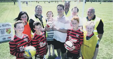  ??  ?? Members of Amazon’s Peterborou­gh charity committee with Park Farm Pumas FC Photo: Tim George