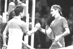  ??  ?? Japan’s Kei Nishikori (L) greets Switzerlan­d’s Roger Federer after winning their singles round robin match 7-6, 6-3 on day one of the ATP World Tour Finals tennis tournament at the O2 Arena in London on November 11, 2018. - AFP photo