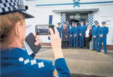  ??  ?? Police Area Commander Hawke’s Bay Inspector Jeanette Park, takes a photo as police staff stand with Police Commission­er Andrew Coster in front of the new CHB Multi Agency Centre.