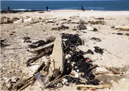  ?? (Amir Cohen/Reuters) ?? CLUMPS OF tar mar the sand at a beach in Ashdod after an offshore oil spill polluted much of Israel’s Mediterran­ean shoreline last week.