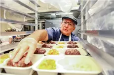  ??  ?? Barak Wolff, a volunteer of seven years for Kitchen Angels, prepares a meal Tuesday at the Santa Fe Convention Center Community Kitchen.