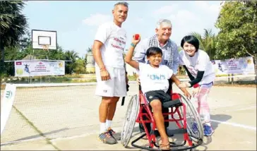  ?? PHOTO SUPPLIED ?? Saim Kimsua, with Father Enrique Figaredo (centre) and Tep Rithivit (left), receives his first sports wheelchair from the ITF and Stop War Start Tennis at a donation event in 2015.