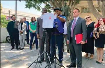  ?? CHRISTOPER WEBER / AP ?? During a news conference Thursday in Los Angeles, Jonathan Wright, 39, holds up the T-shirt he was given when he first went to MacLaren Children’s Center in El Monte as an 8-year-old. He said he was sexually abused by a physician there. A Los Angeles County-run shelter meant to be a safe space for children as they awaited placement in foster homes was for decades a den for sexual predators among the staff — and some residents — who preyed on children as young as 5, according to a lawsuit filed Thursday by dozens of former residents.