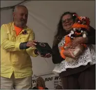  ?? ?? Dog-parents Wendy Bissett and Larry Solak of Oberlin hold up Sprinkle, 1, their long-haired chihuahua that won first place in the pet and animal costume contest of the 49th Annual Woollybear Festival Oct. 10in Vermilion.