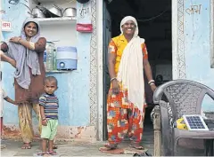  ??  ?? Radha Devi, wearing her yellow Solar Saheli vest, stands in the courtyard of her home in Moonpur village in western Rajasthan.