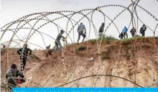  ?? — AFP ?? Palestinia­ns go through a barbwire fence into Israel as they attempt to cross to reach their workplaces close to the Israeli checkpoint of Mitar near Hebron in the occupied West Bank yesterday.