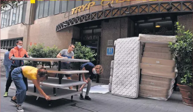  ??  ?? Voluntario­s recogen las camas y colchones donados por el hotel Tryp Cibeles, de Madrid, para familias desfavorec­idas que sufren los efectos de la crisis provocada por el COVID-19.