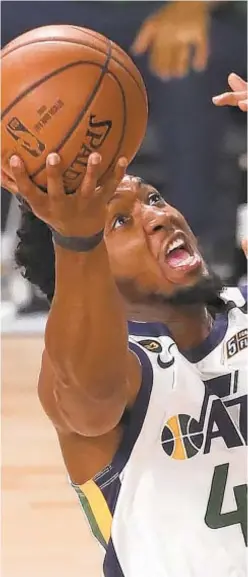  ?? GETTY ?? Utah’s Donovan Mitchell scores two of his 30 points against Denver defense on Wednesday as Jazz evens series, 1-1.