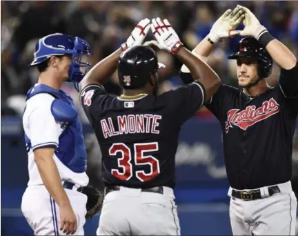  ?? FRANK GUNN — CANADIAN PRESS ?? Yan Gomes, right, is congratula­ted by Abraham Almonte after hitting a three-run home run against the Blue Jays during the eighth inning