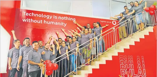  ?? Picture: ABISHEK CHAND ?? Vodafone Fiji staff members pose for a photo showing the new tagline for the company that was launched yesterday.