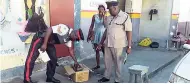  ?? GARETH DAVIS SR PHOTO ?? Deputy Superinten­dent of Police Oniel Thompson (right) oversees the confiscati­on of illegal DVDs from a vendor in Port Antonio by another lawman.