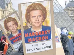  ?? AP ?? Protesters in Paris hold placards showing a photo montage of late British prime minister Margaret Thatcher and French President Emmanuel Macron on Monday.