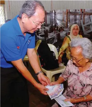  ??  ?? Muchneeded cash: One of the oldest recipients Voon Oi Yoke, 83, receiving her cash from Lim.