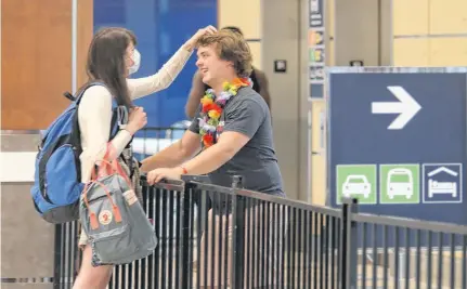  ?? TIM KROCHAK • THE CHRONICLE HERALD ?? Chloe Puddister greets her boyfriend, Hayden Goss, as the couple reunites after spending the last three-and-a-half months apart, in the baggage area of Halifax Stanfield Internatio­nal Airport on Thursday. Chloe had just arrived from a flight from St. John’s, N.L. Tomorrow the Atlantic Bubble opens, allowing for travel within the Atlantic provinces without self-isolating.
