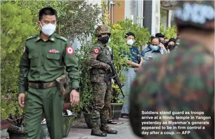  ??  ?? Soldiers stand guard as troops arrive at a Hindu temple in Yangon yesterday as Myanmar’s generals appeared to be in firm control a day after a coup. — AFP