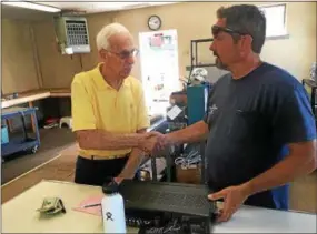  ?? PETE BANNAN — DIGITAL FIRST MEDIA ?? Gus Rubino is closing his repair shop after 48 years in Malvern. “This goes back to my first stereo,” said Dave Lignore of St. Peter’s, who stopped in to pick up his repaired Technics receiver and was the last customer in the store. Lignore was surprised to hear he was closing.