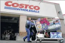  ?? ASSOCIATED PRESS ?? A shopper leaves a Costco store in Portland, Ore. Costco said Thursday that it will raise its pay for minimum-wage workers.