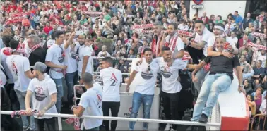  ??  ?? BAÑO DE MASAS. Los jugadores de la Cultural pasearon su alegría por las calles de León en un autobús.