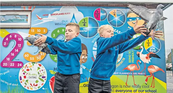  ??  ?? Rory MacFarlane, left, and Jaylen Allan at St Andrew’s School in Oswaldtwis­tle, where pupils have been learning about geography and maths through pigeon racing after teachers installed a loft