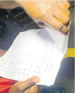  ?? PHOTOS BY AINSWORTH MORRIS ?? Astley Whye peruses a list of his outstandin­g traffic fines printed from a government database. The bus driver claims some of those obligation­s had already been settled.