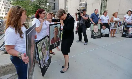  ?? STUART CAHILL PHOTOS / HERALD STAFF ?? ‘NEED TO SEE THE FAMILIES’: Attorney General Maura Healey gets emotional as she greets Melinda Guerrini, who lost her daughter Kailey, as protesters holding signs of their lost loved ones rally outside Suffolk Superior Court on Friday. Assistant Attorney General Sandy Alexander, below left, greets Cheryl Juaire, who lost her son Corey.