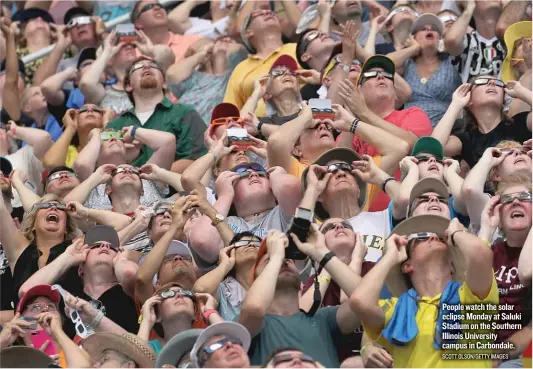  ?? SCOTT OLSON/ GETTY IMAGES ?? People watch the solar eclipse Monday at Saluki Stadium on the Southern Illinois University campus in Carbondale.